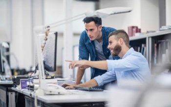 ERP-System Filialgeschäft - 2 Männer vor dem Monitor
